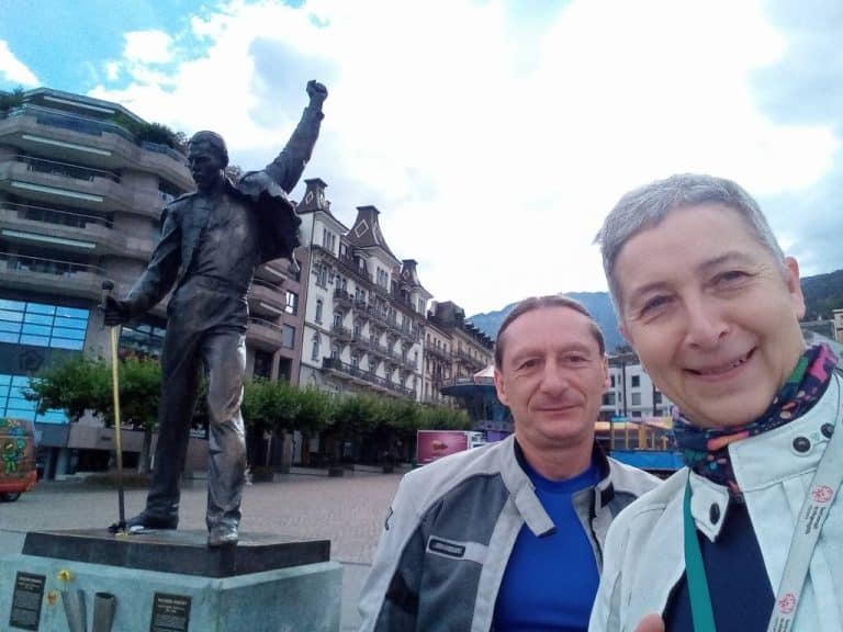 Selfie of pair on motorcyle holiday with Freddie Mercury statue